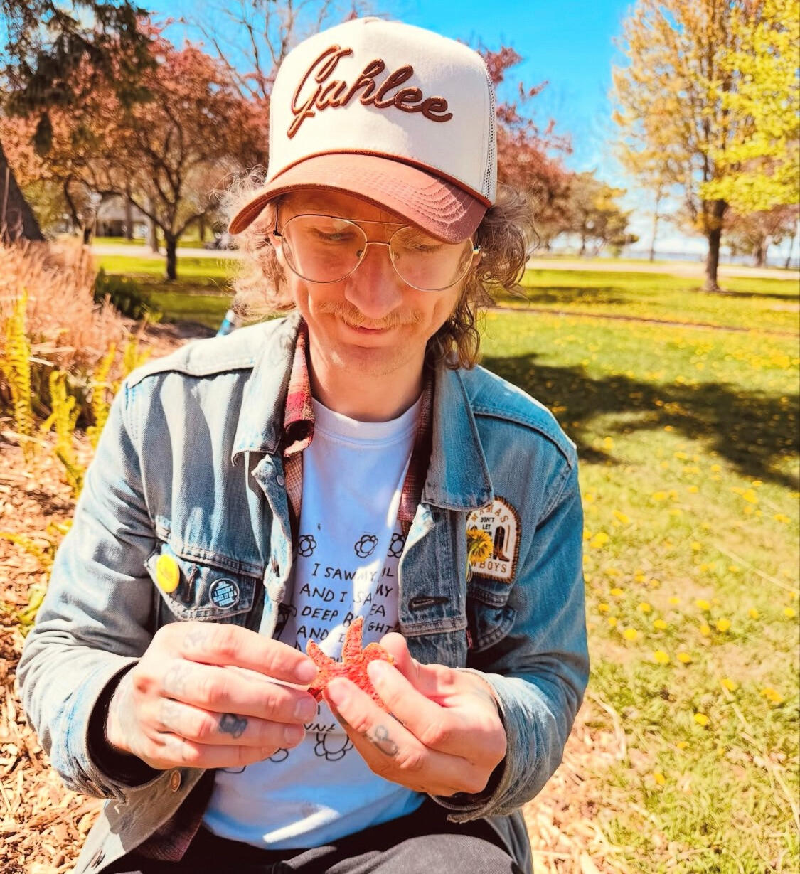 C.Halle A local musician sitting in a field holding a small creature.